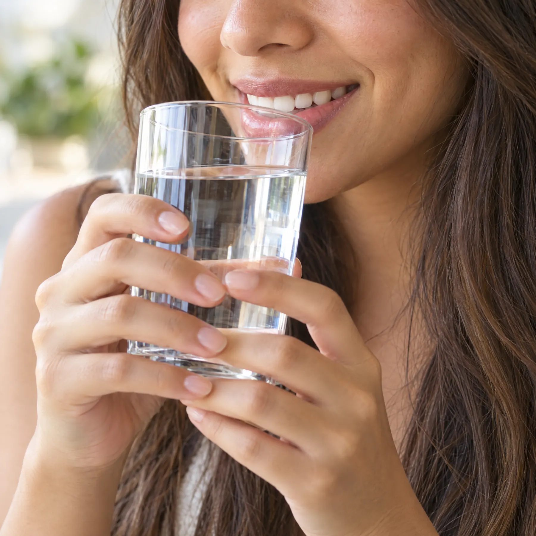 Mujer sonriendo con un vaso de agua